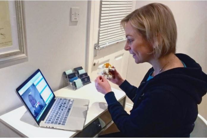 Woman video chatting on laptop at home.