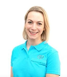 Smiling person in blue polo shirt on white background.