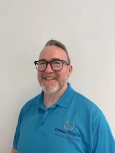Smiling man in Omnia Physio branded shirt