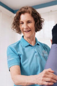 Physiotherapist assisting with leg exercise